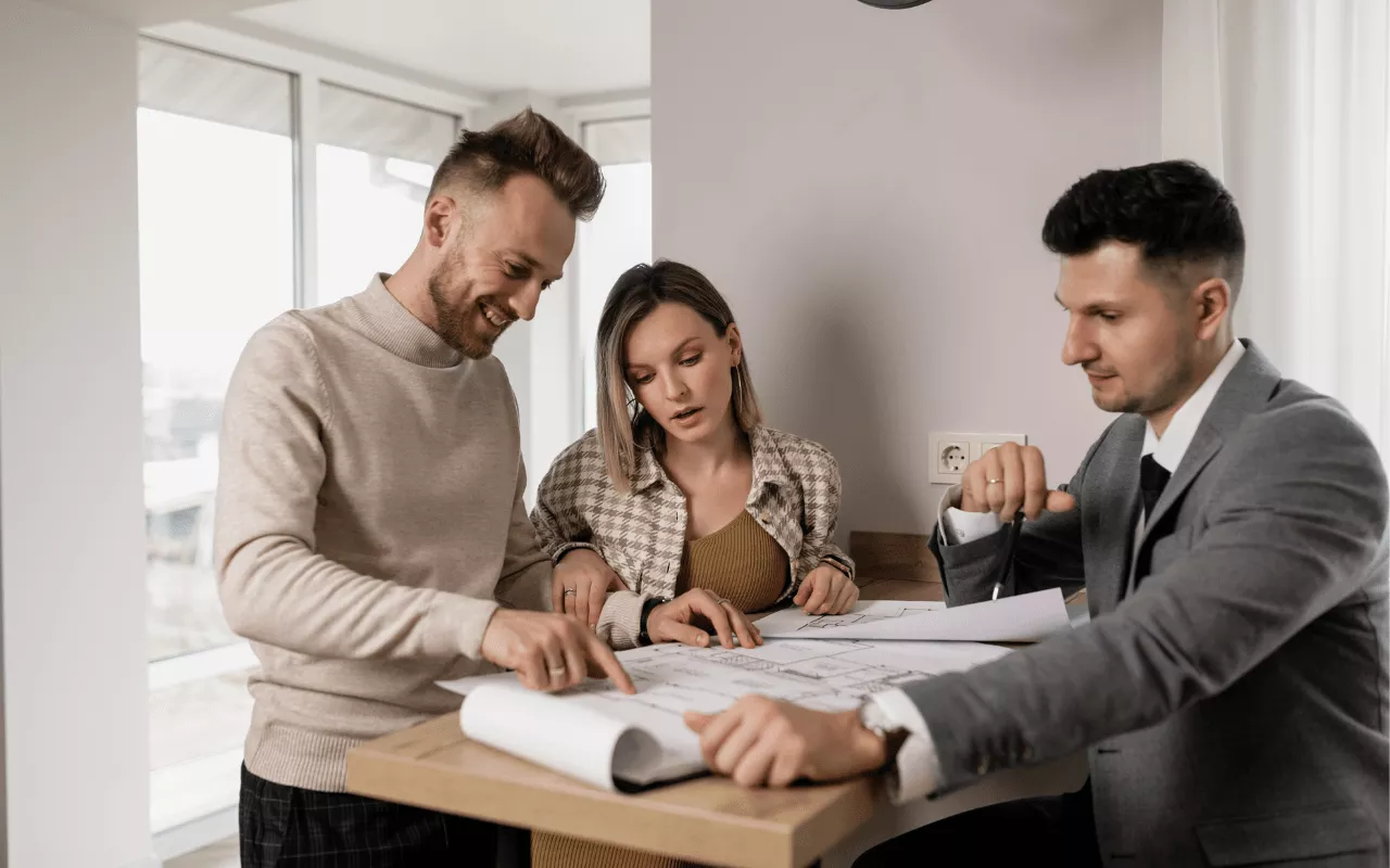 Asesor inmobiliario hablando con un cliente, tomando notas durante una entrevista