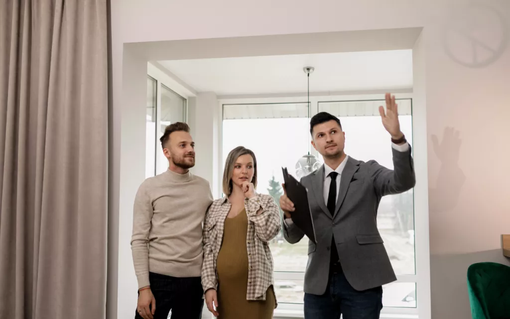 Asesor inmobiliario acompañando a un cliente durante una visita a una propiedad, brindando apoyo personalizado.