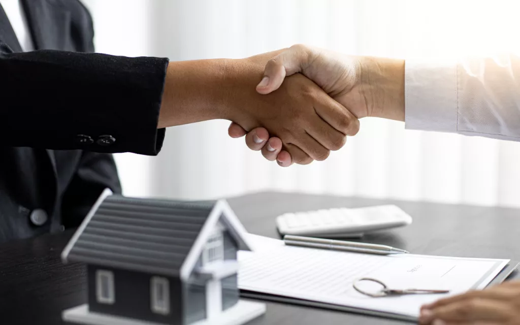 Imagen de un apretón de manos o de personas discutiendo una negociación efectiva más allá del precio.